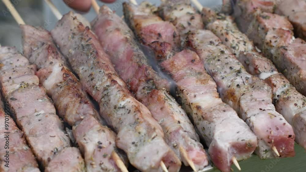 young man grilling meat kebabs on coals, ARROSTICINI - typical southern Italian cuisine, a luxurious picnic on the terrace near the house in summer,aromatic smoke rises from the barbecue, young man grilling meat kebabs on coals, ARROSTICINI - typical southern Italian cuisine, a luxurious picnic on the terrace near the house in summer,aromatic smoke rises from the barbecue,
