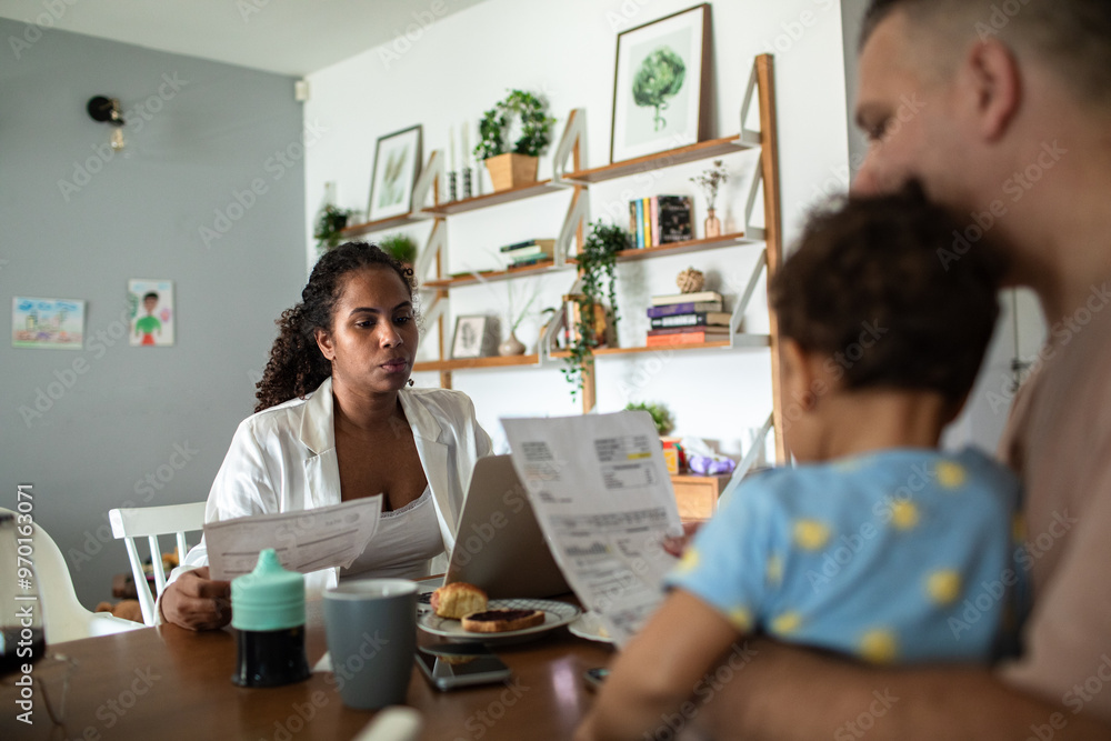 Couple managing bills with baby while working from home Couple managing bills with baby while working from home