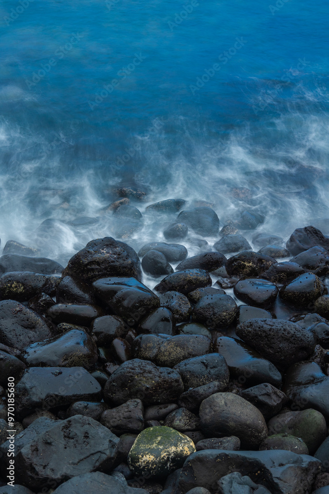 Overhead shot of black rocky beach with blue sea waves. Concept: Beach, volcano, holidays, travelling. Overhead shot of black rocky beach with blue sea waves. Concept: Beach, volcano, holidays, travelling.
