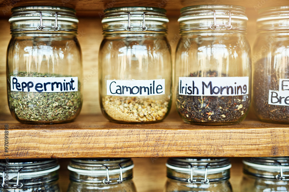 Container, jar and tea leaves on shelf at cafe for catering, organic flavor and drink in closeup. Collection, antioxidant and natural herbs with stock, inventory and label for beverage at coffee shop Container, jar and tea leaves on shelf at cafe for catering, organic flavor and drink in closeup. Collection, antioxidant and natural herbs with stock, inventory and label for beverage at coffee shop