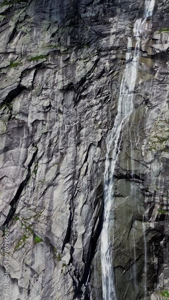 A Majestic 4k Waterfall is Cascading Down the Rocky Cliff Face in a Stunning Natural Landscape in Norway , Portrait Orientation A Majestic 4k Waterfall is Cascading Down the Rocky Cliff Face in a Stunning Natural Landscape in Norway , Portrait Orientation