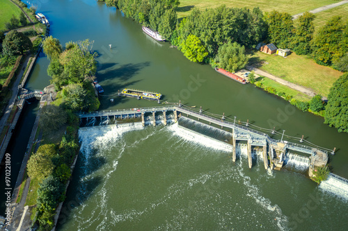 An aerial view of a river with a watermill , lock system and a weir