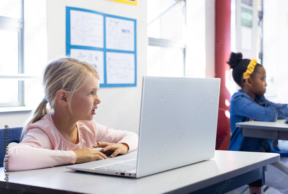 In school, girl using laptop in classroom, focusing on learning activities In school, girl using laptop in classroom, focusing on learning activities