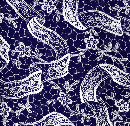 Close-up of intricate white lace on a blue background, featuring delicate floral and paisley patterns.