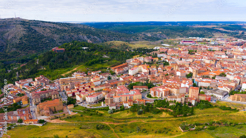 Obraz premium Aerial view of small Spanish city of Soria on background of picturesque landscape with river and green hills ..