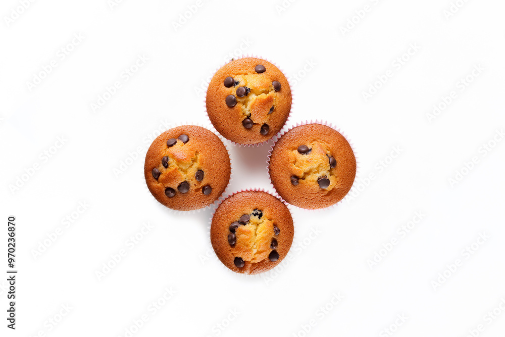 Four delicious, freshly baked muffins with chocolate chips on top. Overhead shot on white background. Four delicious, freshly baked muffins with chocolate chips on top. Overhead shot on white background.