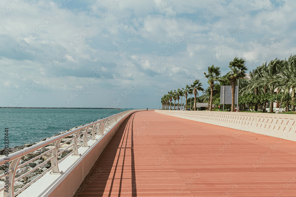 Fototapeta premium Scenic beachfront promenade with palm trees and ocean view