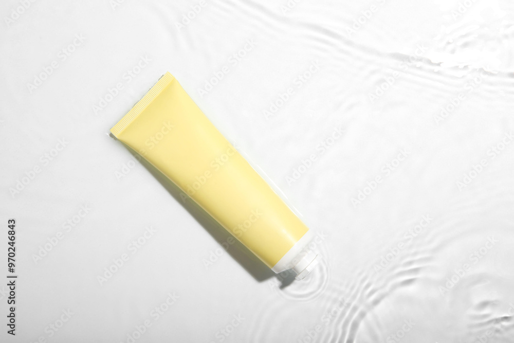 Cosmetic product. Tube with cream in water on light background, top view Cosmetic product. Tube with cream in water on light background, top view