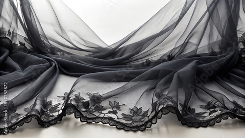 Ethereal elegance flows from black tulle fabric's transparent layers, trimmed with delicate lace, creating an