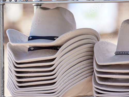 A Stack of Western Style Cowboy Hats on a Rack for Sale photo