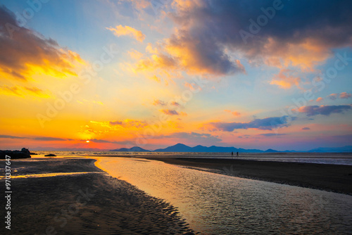 Sunset view of water on sand at Dadaepo beach with the background of mountains near Saha-gu, Busan, South Korea  photo