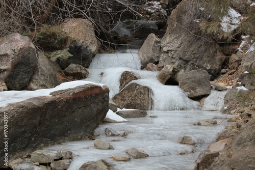 frozen stream with rocks in winter 
