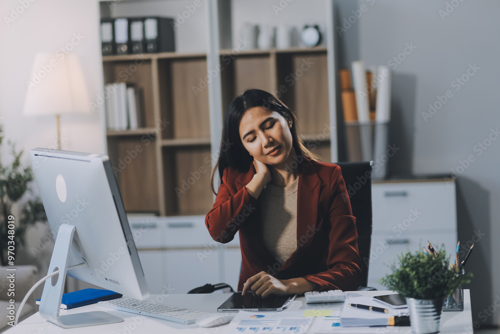 Asian woman working hard in the office having aches and pains in her torso and waist Asian woman working hard in the office having aches and pains in her torso and waist