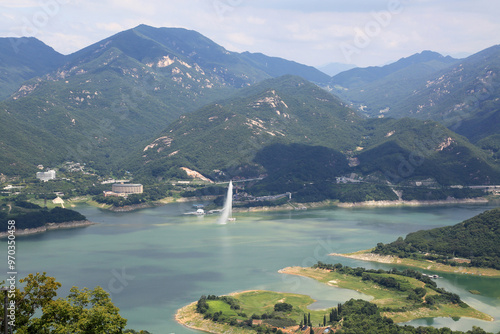 Jecheon-si, Chungcheongbuk-do, South Korea - August 14, 2019: Aerial view of water fountainon on Chungjuho Lake with Cheongpung Resort Lake hotel under Jakseongsan Mountain photo