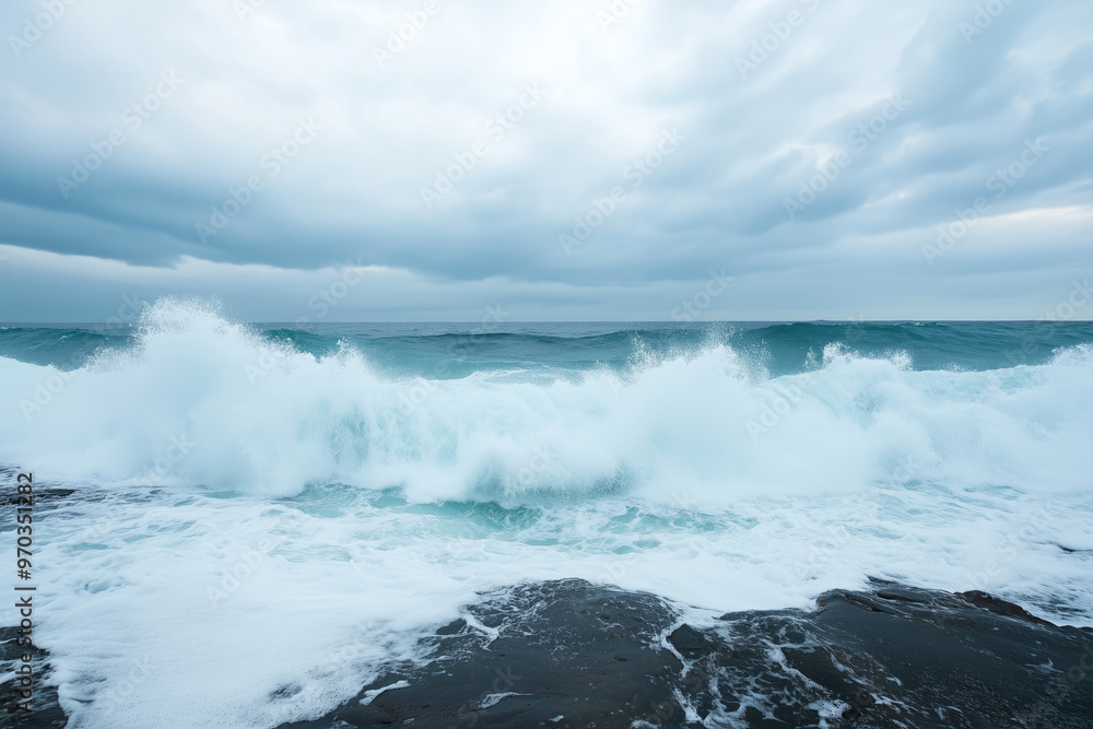 Powerful ocean waves crashing against a rocky shore, with a dramatic cloudy sky overhead, moody seascape Powerful ocean waves crashing against a rocky shore, with a dramatic cloudy sky overhead, moody seascape