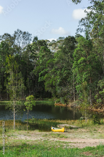 Yellow canoe sitting on the edge of a lake