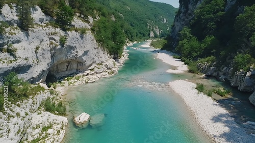 A serene turquoise river flows through lush green mountains.