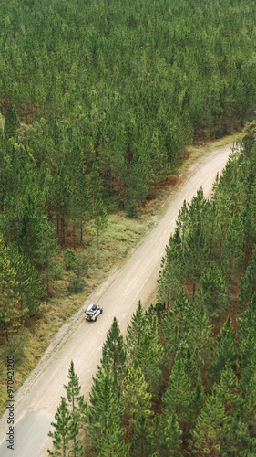 drone image of a land rover driving through a forest