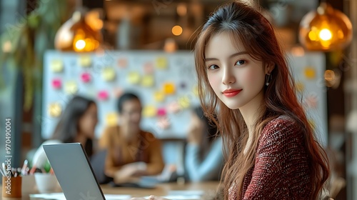 A dynamic startup environment featuring a woman working on her laptop, with whiteboards covered in post-its and business ideas, energetic team collaboration happening in the background, photo