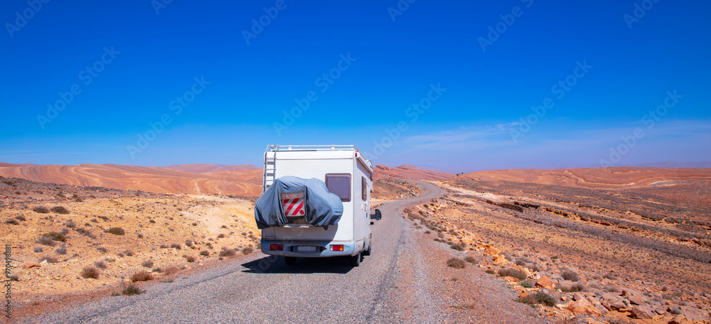 Obraz premium Campervan Alone on a Desert Road in a Scenic Wilderness