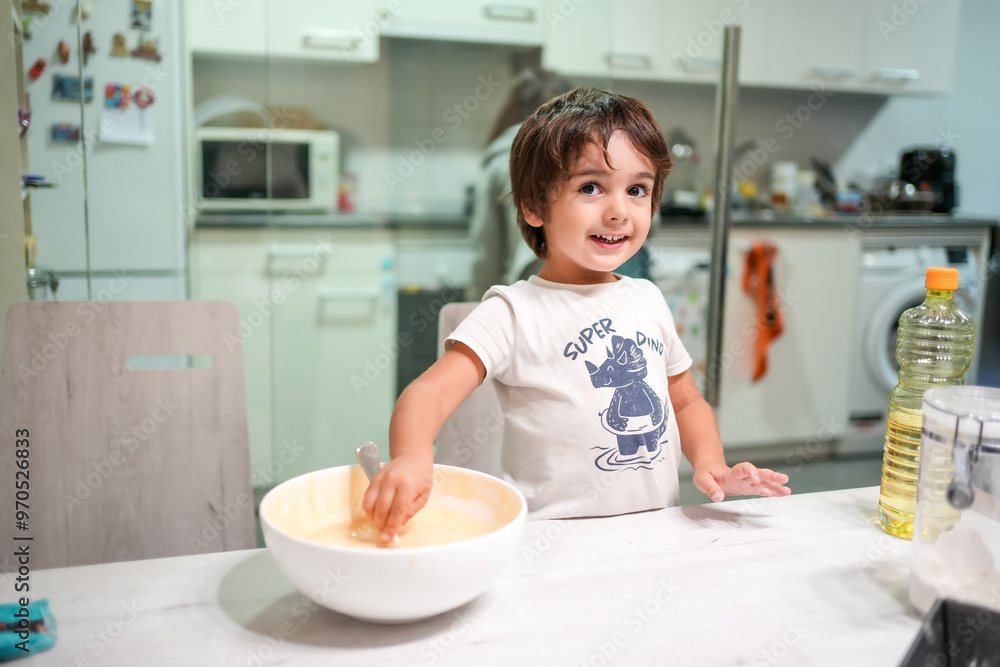 A young boy is standing in front of a bowl of batter A young boy is standing in front of a bowl of batter