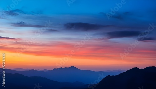Wallpaper Mural The colorful sky with blue and orange hues creates a dramatic backdrop against the silhouetted mountains. Torontodigital.ca