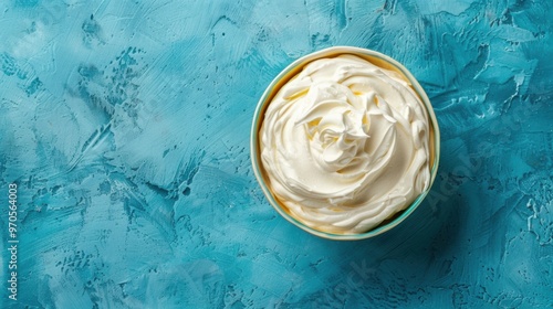 Handcrafted Greek yogurt in a dish on azure backdrop from above with room for text. Natural unflavored Greek yogurt labneh mascarpone creme fraiche for nutritious morning meal photo