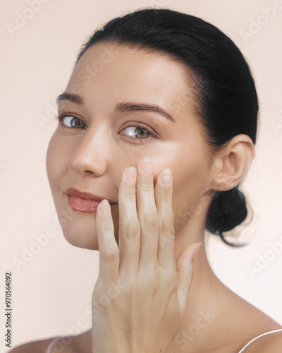 Woman with Radiant Skin Gently Touching Face in Skincare Routine