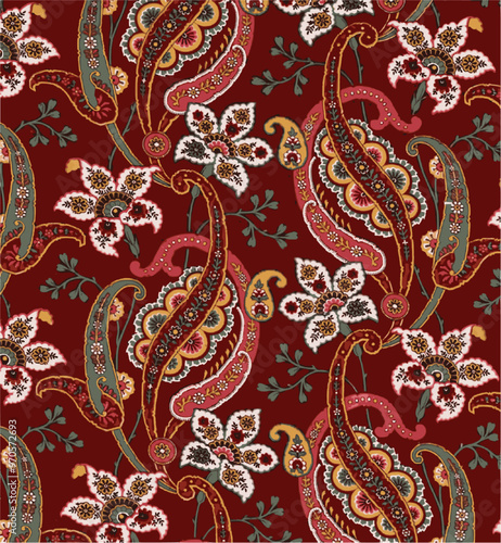 An elegant, intricate paisley pattern with floral accents on a rich red background, suggesting vintage textile design.