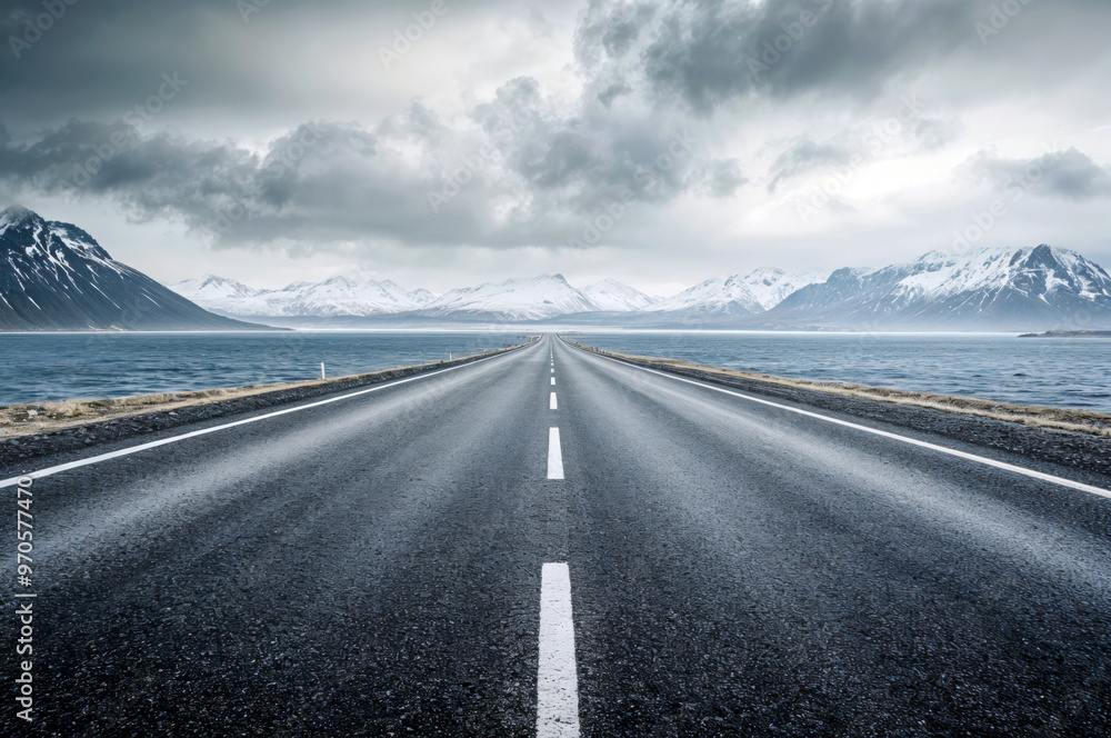 Naklejka premium Empty asphalt road leading to snowy mountain range in iceland