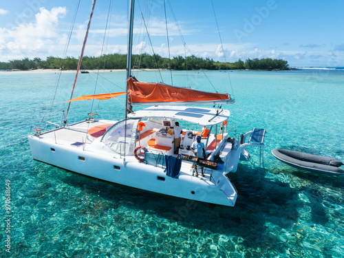 Aerial views of a catamaran in clear blue and greenish water off the coast of a tropical island. Grand Baie, Mauritius