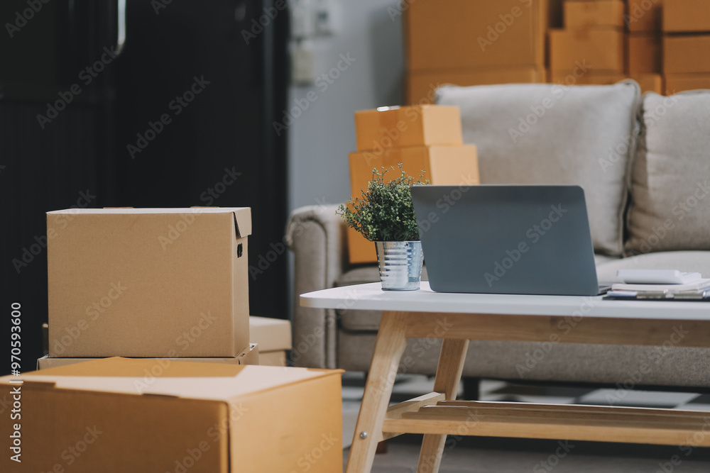 Asian SME business women use laptop computer checking customer order online shipping boxes at home. Starting Small business entrepreneur SME freelance. Online business, Work at home concept. Asian SME business women use laptop computer checking customer order online shipping boxes at home. Starting Small business entrepreneur SME freelance. Online business, Work at home concept.