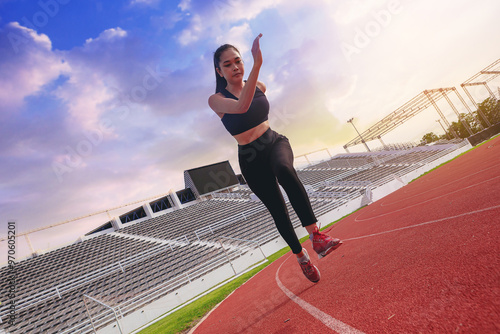 Fit young woman running sprinting at the racetrack. Fit runner fitness runner during outdoor workout at racetrack with high speed zoom blur effect.