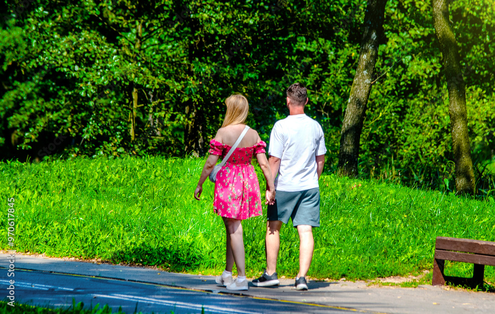 Obraz premium A man and a woman walk in a summer park 