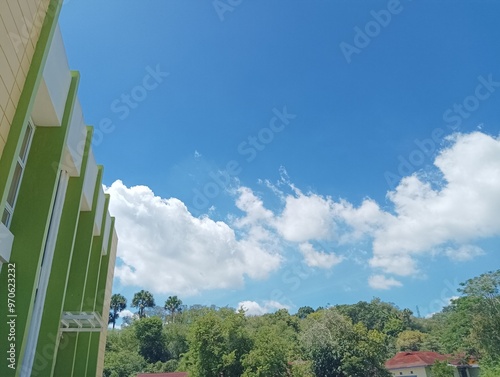 Wallpaper Mural Building with Green Walls Against a Blue Sky with Fluffy Clouds Torontodigital.ca