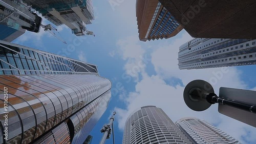 city skyscrapers looking up from bottom to top view in city building and sky with moving cloud