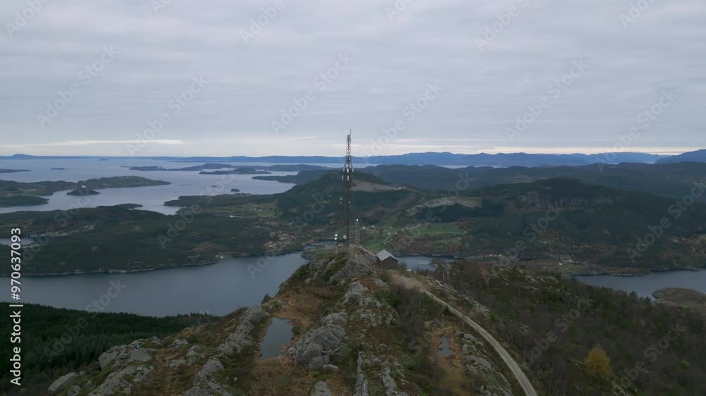 Telecom tower on Lauvåsen mountain overlooking scenic Norwegian fjords and hills, cloudy sky Telecom tower on Lauvåsen mountain overlooking scenic Norwegian fjords and hills, cloudy sky
