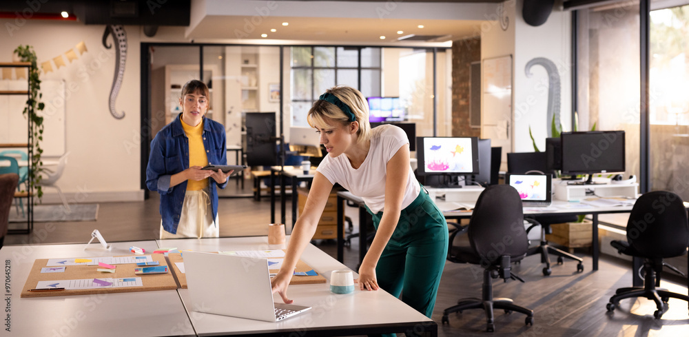 Working in creative office, woman using laptop and sticky notes on desk Working in creative office, woman using laptop and sticky notes on desk
