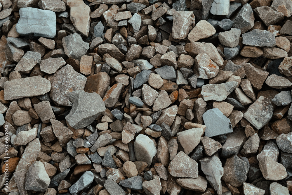 A close-up view of various sizes and shapes of gravel and stone aggregate found in a construction site during daylight hours A close-up view of various sizes and shapes of gravel and stone aggregate found in a construction site during daylight hours