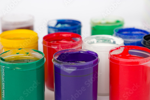Multicolored gouache in plastic cans. Close up view.