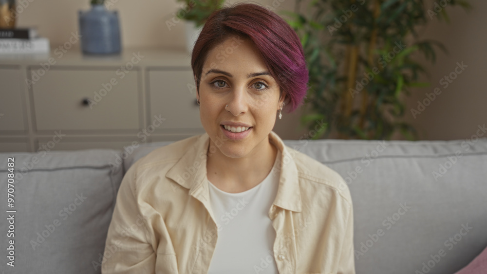 A young, beautiful, caucasian woman with short hair sits comfortably in a living room, showcasing a modern hairstyle, with light indoor decor in the background. A young, beautiful, caucasian woman with short hair sits comfortably in a living room, showcasing a modern hairstyle, with light indoor decor in the background.