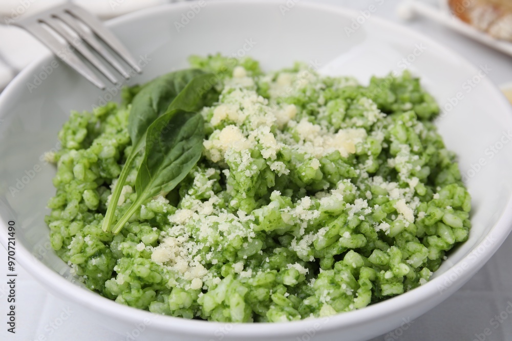 Delicious spinach risotto with parmesan cheese served on white tiled table, closeup Delicious spinach risotto with parmesan cheese served on white tiled table, closeup