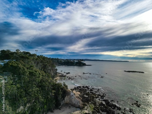 Aerial coastal landscape with lush greenery and rocky shoreline