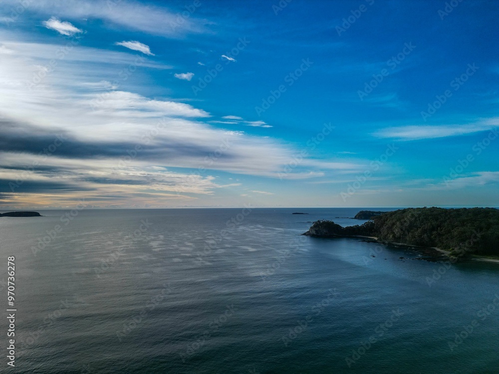 Serene coastal landscape with blue skies and calm waters Serene coastal landscape with blue skies and calm waters