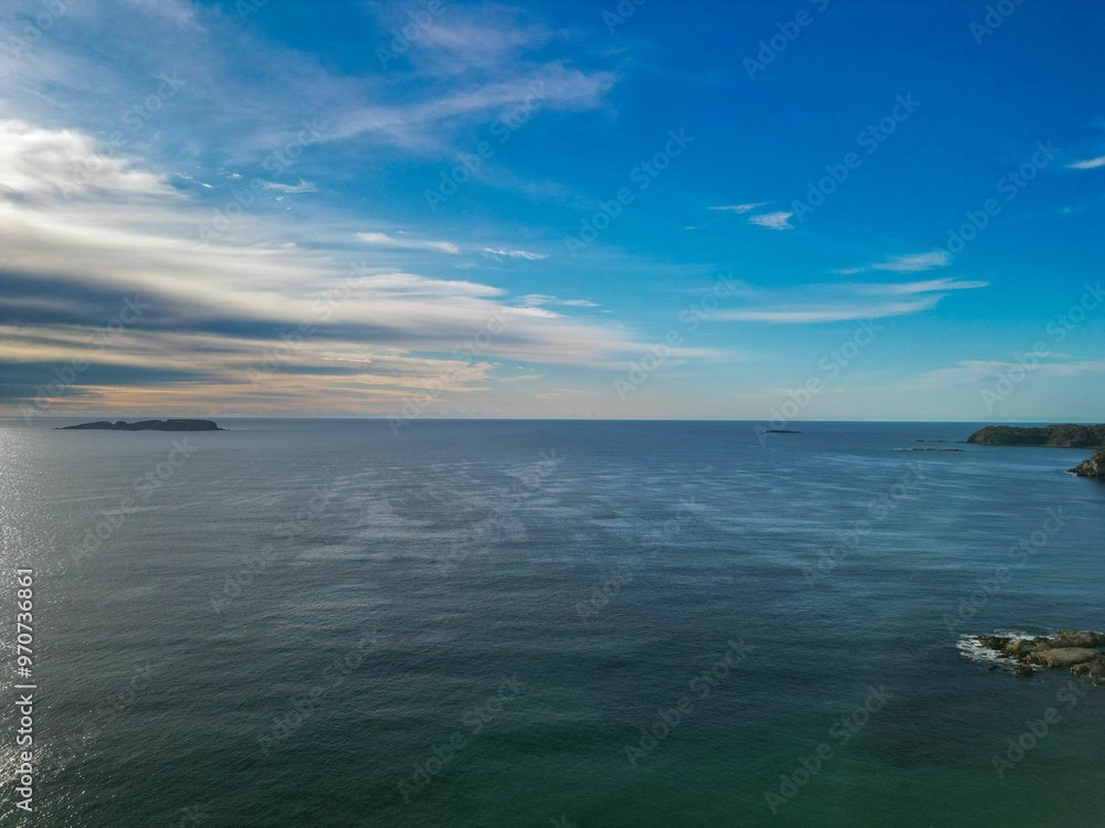 Obraz premium Serene seascape with clear blue sky and distant islands