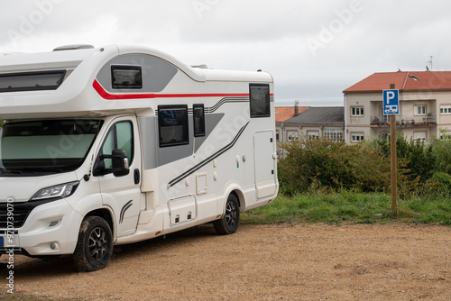 Campervan in camp parking near beach at coastline. Family rv camper van vehicle at seaside. Rving motorhome lifestyle travel to sea. Travel on Campervan along Spain coast. Caravaning Parking. Camping photo