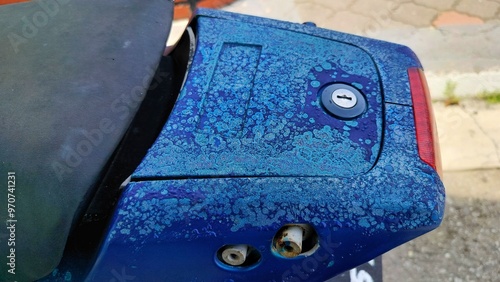 faded paint on the motorcycle coverset. the condition of an old motorcycle with peeling paint photo