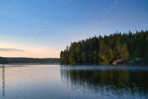 Bay in a lake in Sweden with blue water and trees on the shore. Scandinavian nature