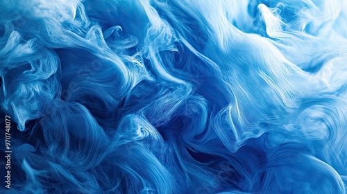 A creative shot of blue abstract paint swirling on a canvas with a matching blue background, representing creativity. photo