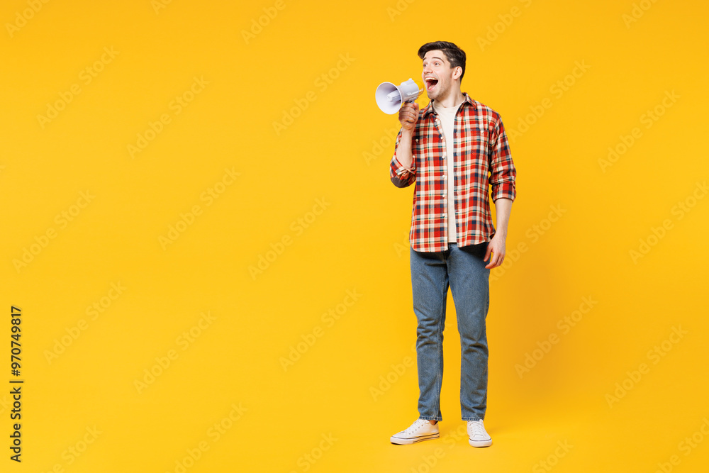 Full body young happy man wears red checkered shirt casual clothes hold in hand megaphone scream announces discounts sale Hurry up isolated on plain yellow orange background studio. Lifestyle concept. Full body young happy man wears red checkered shirt casual clothes hold in hand megaphone scream announces discounts sale Hurry up isolated on plain yellow orange background studio. Lifestyle concept.